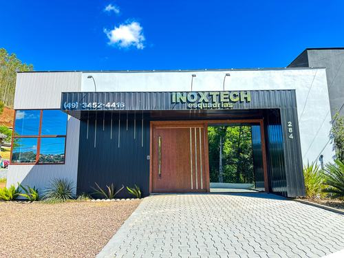 Fachada da Inoxtech com esquadrias de vidro e madeira